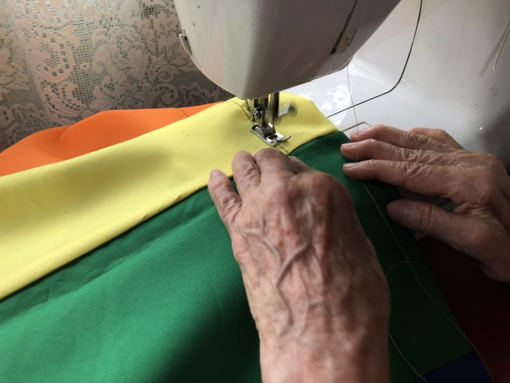 Elena cosiendo una bandera LGBTI