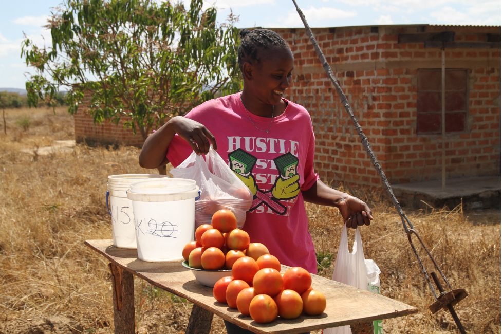 Lydia Mtonga sells some tomatoes she grows on her farm.