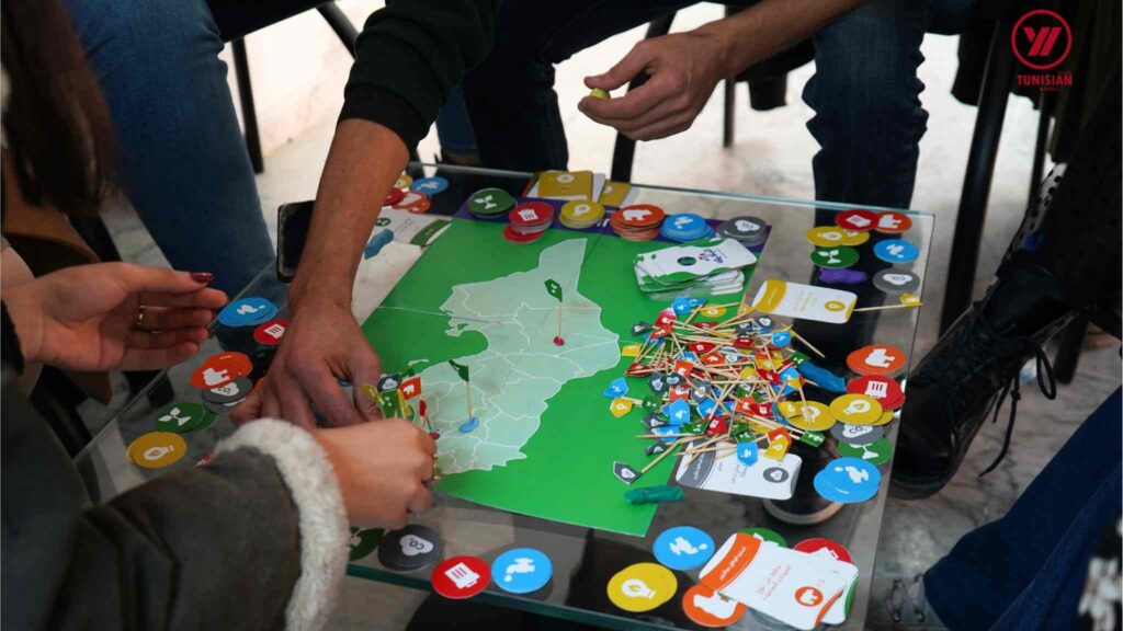 Tunisian youth playing a climate card game where they must collect discs based on challenges and missions about climate change and Tunisian ecosystems. 